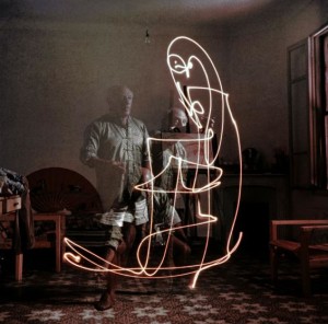 Triple exposure of artist Pablo Picasso drawing w. light at his home in Vallauris.